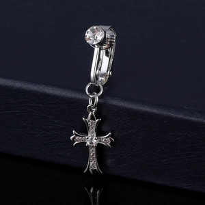 Macro shot of silver cross navel ring with zircon inlay on black leather background