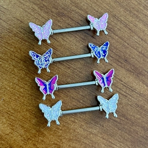 Set of four stainless steel butterfly nipple barbells with colorful glitter oil drip designs
