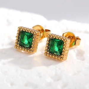 Détail d'un clou d'oreille carré doré avec zircon émeraude et bordure perlée rétro