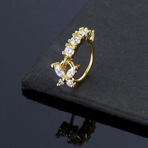 Macro detail of golden butterfly nose ring with sparkling cubic zirconia on black stone