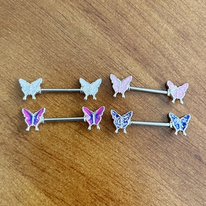 Macro detail of multi-colored glitter butterfly nipple rings in 316L stainless steel