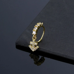 Macro shot of gold non-piercing nose ring with cubic zirconia stones and anchor pendant