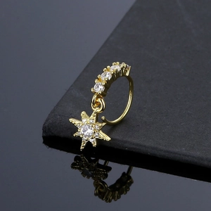 Detailed macro view of golden star nose ring with cubic zirconia on a reflective base
