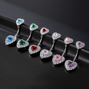 Dettaglio ravvicinato di piercing all'ombelico a forma di cuore con zirconi colorati intarsiati