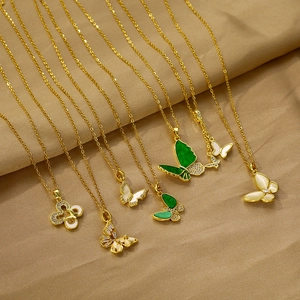 Colliers papillons dorés élégants avec émail et zircons sur fond de satin champagne