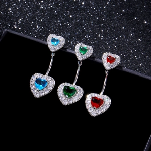 Vista macro di piercing all'ombelico a cuore con zirconi blu, verdi e rossi