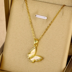 Gros plan du collier papillon doré avec ailes en nacre et incrustation de zircon