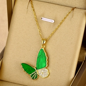 Vue macro d'un pendentif papillon en émail vert et oxydes de zirconium sur chaîne dorée