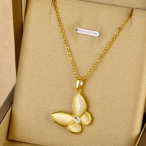 Détail d'un pendentif papillon doré avec ailes effet opale et incrustation zircon