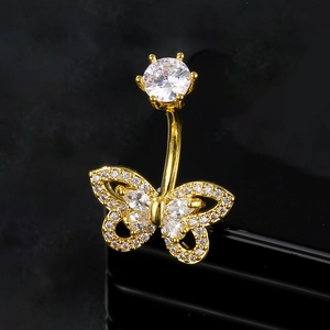 Macro detail of golden butterfly belly ring with sparkling zircon inlays on black stand