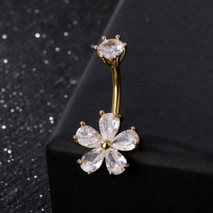 Macro view of gold floral belly ring with pear-shaped cubic zirconia on black box