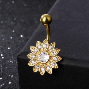Golden sunflower belly button ring with sparkling zircons on a textured display
