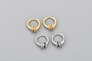 Détail de boucles d'oreilles créoles dorées et argentées avec anneaux amovibles en zircon