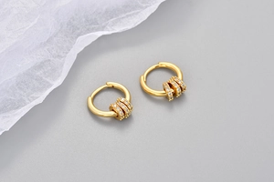 Détails de boucles d'oreilles créoles dorées avec breloques en oxydes de zirconium