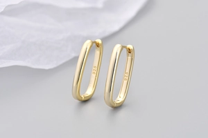 Dettaglio degli orecchini a U in oro lucido che mostrano il marchio in argento 925