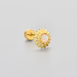 Macro shot of gold sunflower stud earring featuring a central opal and flat back screw