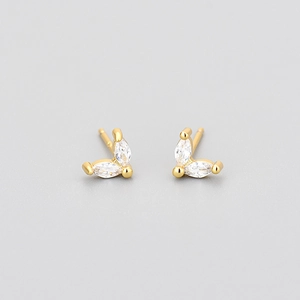 Vue macro détaillée de boucles d'oreilles papillon dorées avec zircons marquises