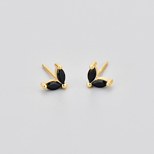 Vue macro de boucles d'oreilles papillon dorées avec pierres marquise noires en forme de V