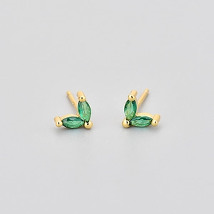 Détail de boucles d'oreilles papillon dorées avec pierres de cristal vertes marquise