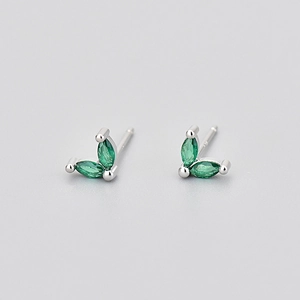 Vue macro détaillée des boucles d'oreilles papillon en argent avec pierres vertes
