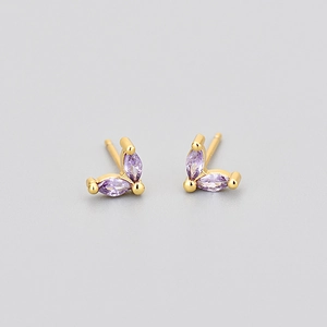 Détails macro de boucles d'oreilles papillon dorées avec pierres violettes marquise