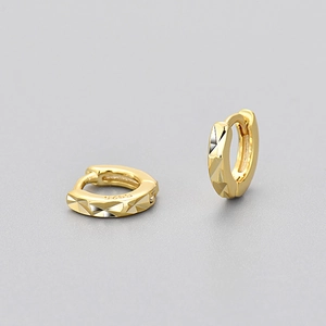 Makroaufnahme goldener geometrischer Ohrringe mit S925-Stempel und facettierter Textur