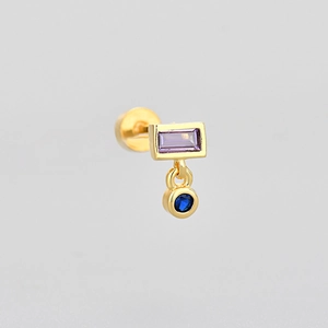 Detailed view of golden stud earring featuring purple rectangular and blue round stones