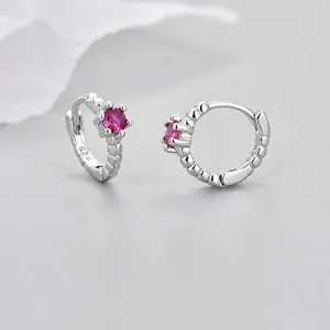 Detailed macro view of 925 silver hoop earrings with pink zircon and s925 stamp