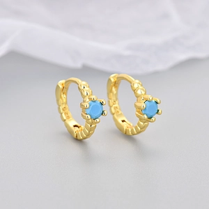 Detail of S925 stamped gold-plated hoop earrings with turquoise zircons and threaded texture