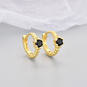 Detailed macro view of S925 sterling silver huggie earrings with black zircon and gold plating