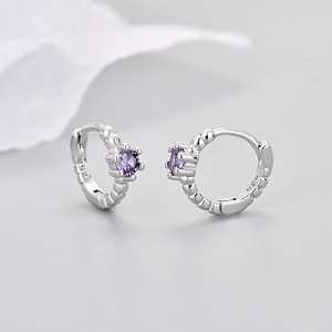 Detail of S925 silver hoop earring with purple zircon stone and beaded texture