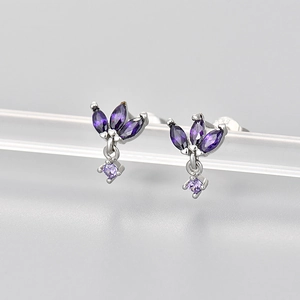 Macro shot of S925 silver stud earrings with marquise-cut purple gems on a display