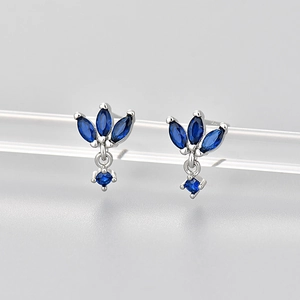 Macro shot of silver stud earrings with marquise dark blue stones on acrylic display stand