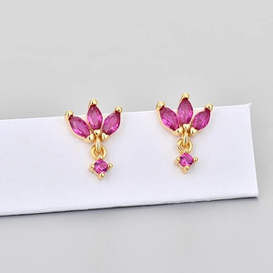Macro detail of gold-plated marquise stud earrings with rose red crystals on display card