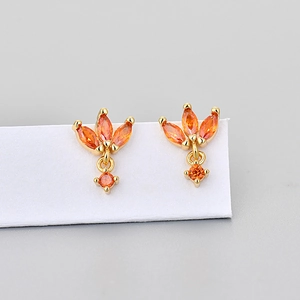 Detail view of gold stud earrings with marquise-cut orange zirconias in floral design