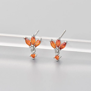 Detail of silver stud earrings with orange marquise gems and diamond-shaped pendant