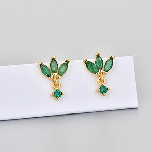 Macro shot of gold marquise stud earrings with green zircon stones on white display card