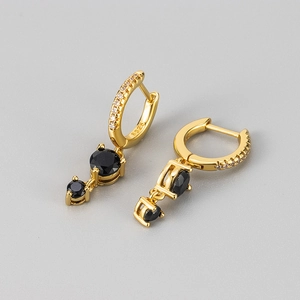 Détail de boucles d'oreilles en argent S925 doré avec pampilles en zircon noir élégantes