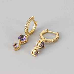 Détail du poinçon S925 sur boucles d'oreilles dorées avec pampilles de zircon violet