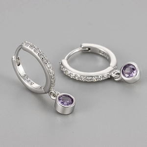 Macro shot of S925 silver hoop earrings with clear micro-diamonds and purple gemstone drop