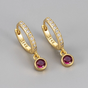 Detailed shot of S925 sterling silver gold earrings with red round zircon and pave accents