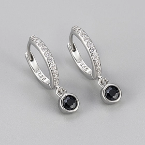 Macro shot of S925 silver hoop earrings with clear pavé stones and black round pendants