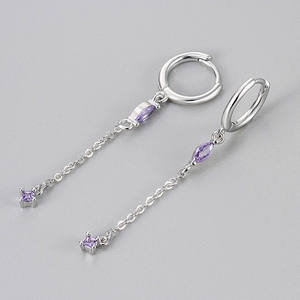Dettaglio degli orecchini a goccia in argento con zirconi viola e lunghe catene pendenti