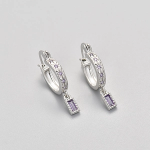 Detail view of silver hoop earrings featuring star patterns and purple zircon drop charms