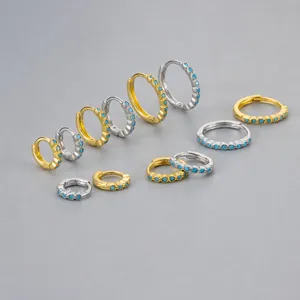 Detailed view of various sizes of turquoise hoop earrings in gold and platinum finishes
