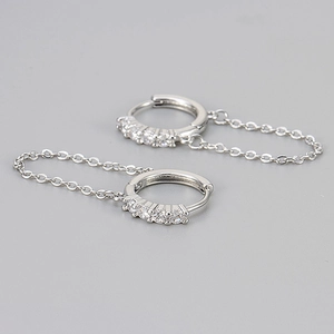 Detailed view of silver hoop earrings with white zircon accents and delicate drop chain
