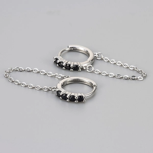 Close-up of silver chain earrings featuring five round-cut black cubic zirconia stones
