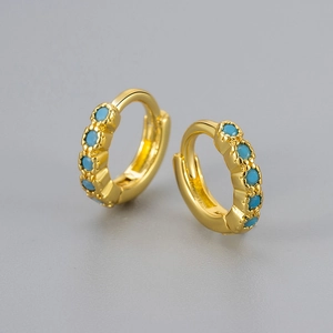 Detailed macro view of gold-plated hoop earring with five turquoise stone inlays