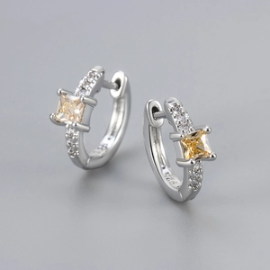Macro shot of silver S925 earrings with square yellow gemstone and micro-pave zircons