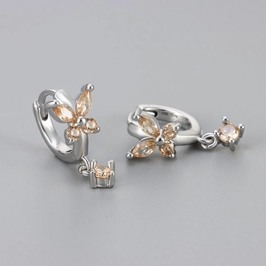 Close-up of silver butterfly earrings with champagne zircons and round crystal drops